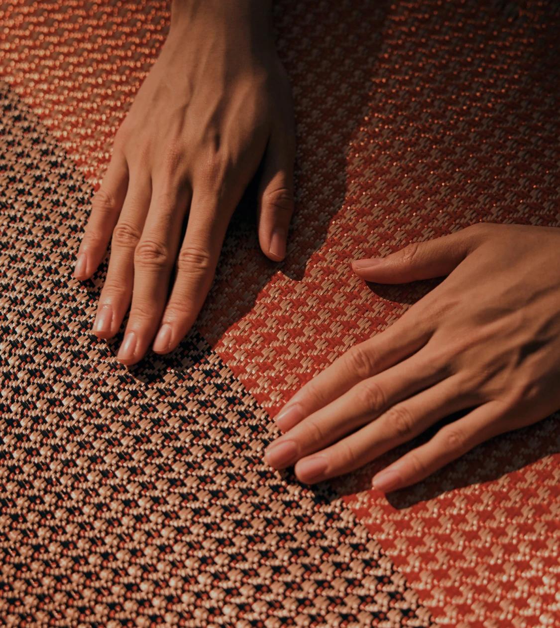 Hands feeling several woven material samples