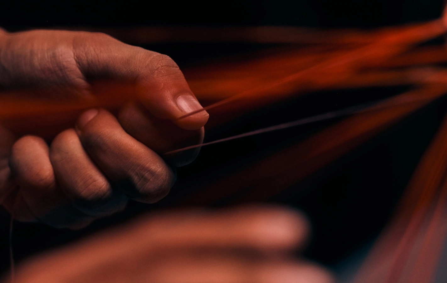 A craftsperson working with a single fiber