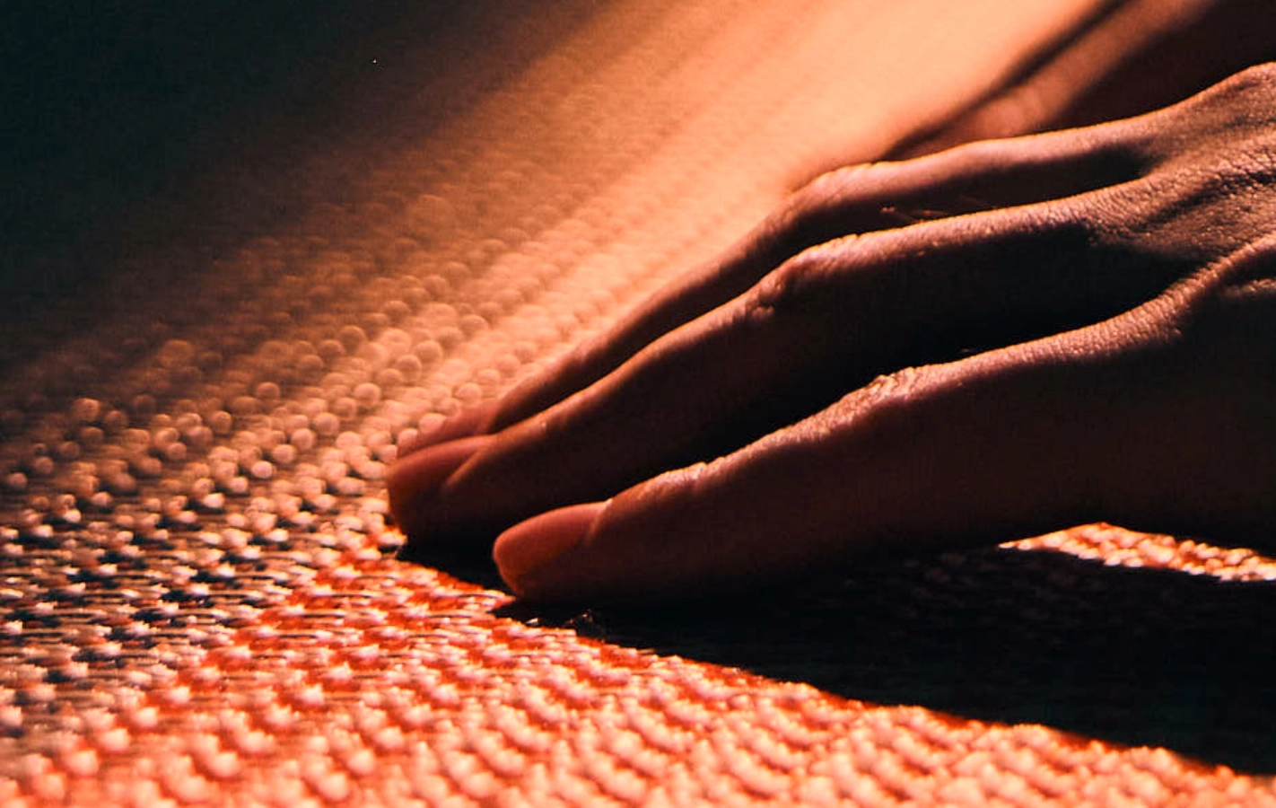 A craftsperson feeling a woven material