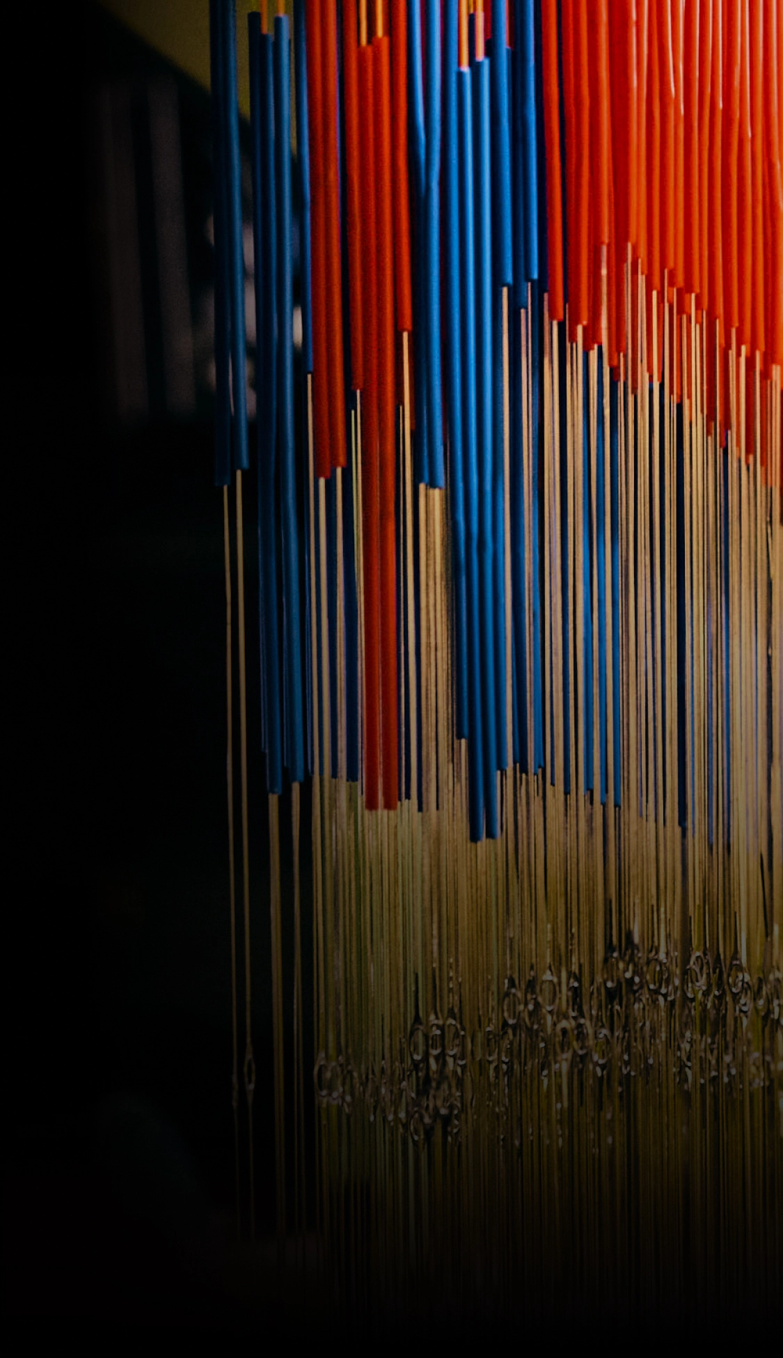 Colorful woven strands hanging in an installation